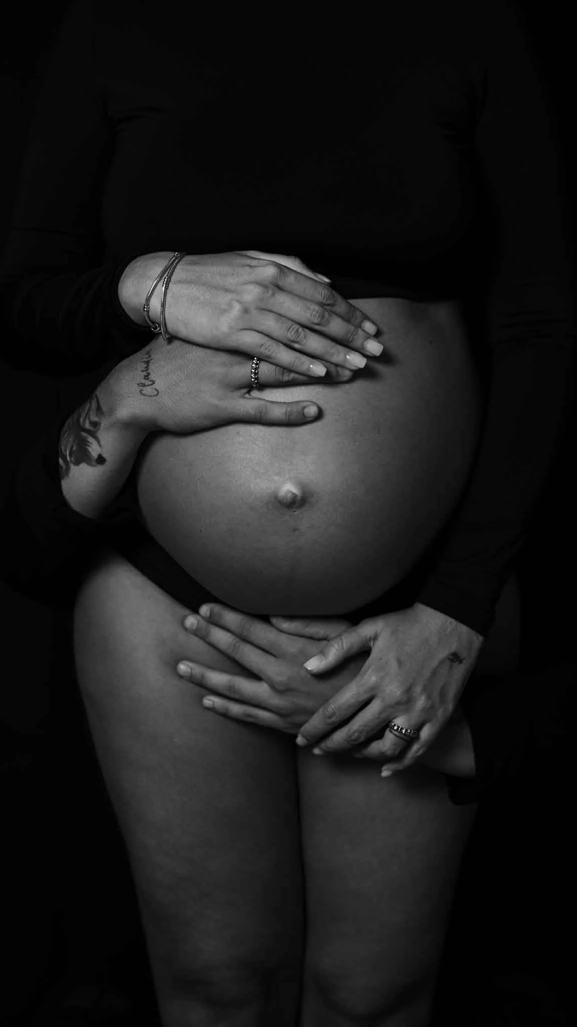 Fotografía artística de embarazada en Sevilla — silueta sobre fondo oscuro